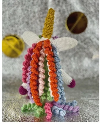 Back view of crochet unicorn showing full rainbow corkscrew curls mane and tail